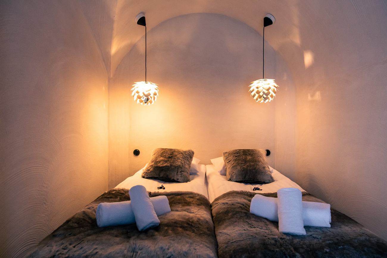 Vaulted hobbit house bedroom interior with soft pendant lighting