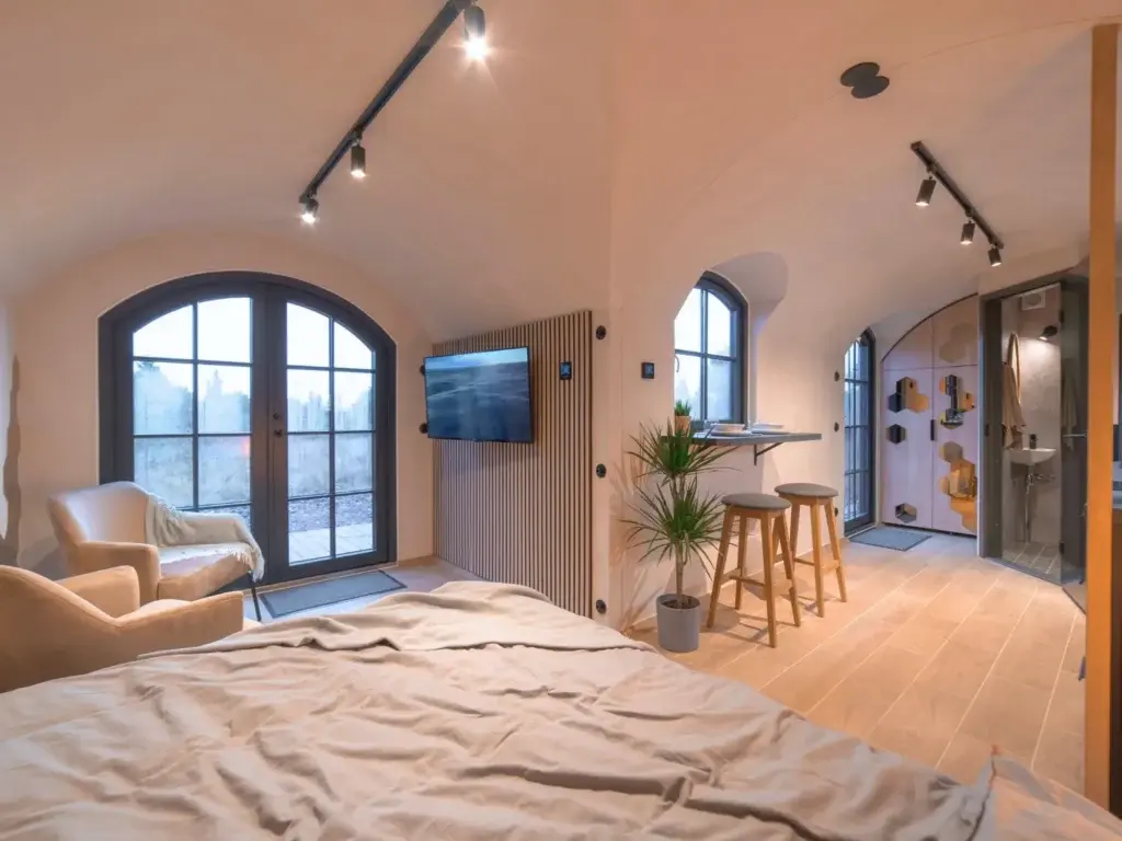 Annexe interior: bedroom, breakfast bar and en-suite bathroom beneath the vaulted ceiling